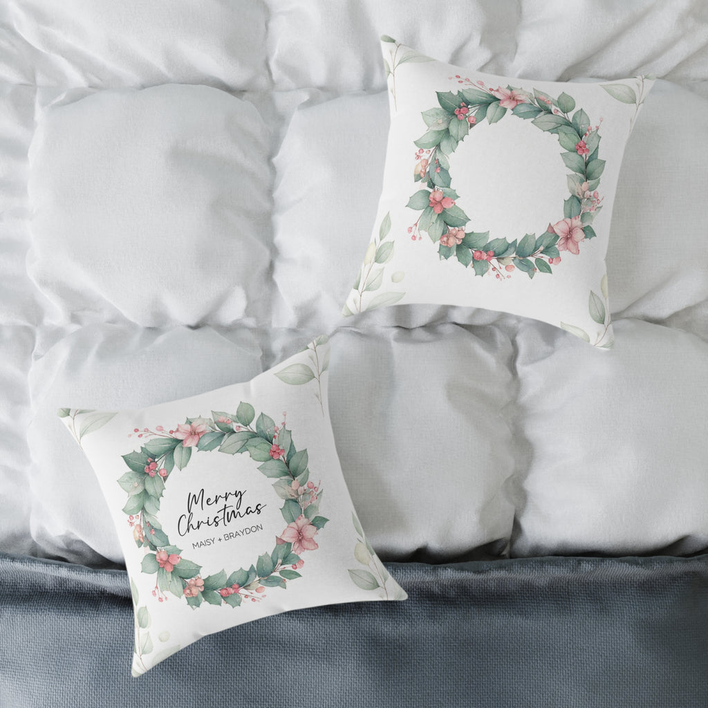 Front and wreath back of the personalized Merry Christmas couple pillow on a white bed