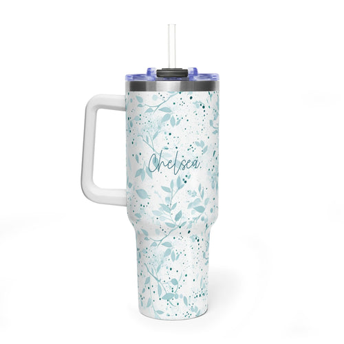 A white handled tumbler with a light blue floral and leaf pattern, featuring the name 'Chelsea' printed in script on the front. The tumbler has a clear lid with a straw and is shown on a clean white background.
