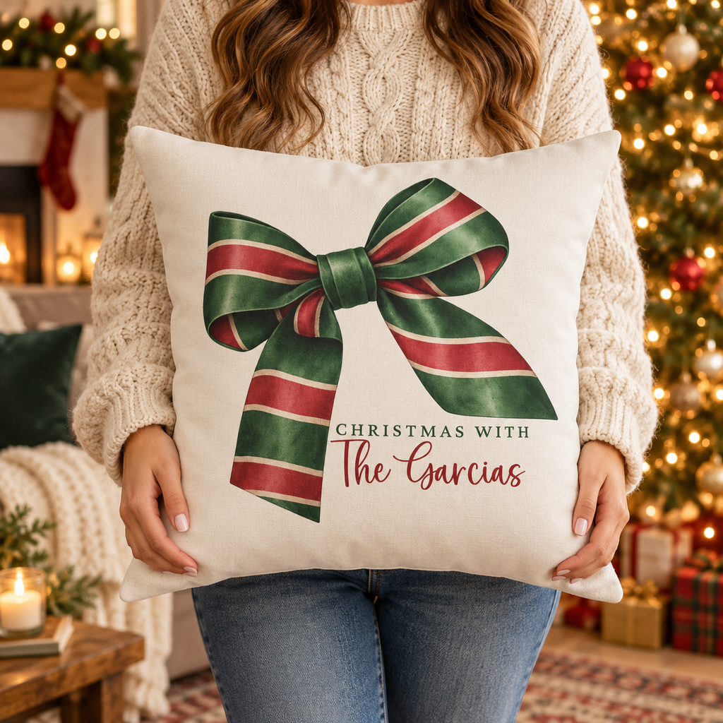 Person holding the personalized striped ribbon bow family name Christmas pillow