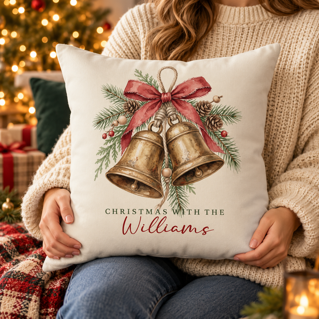 Person holding the personalized brass bells family name Christmas pillow