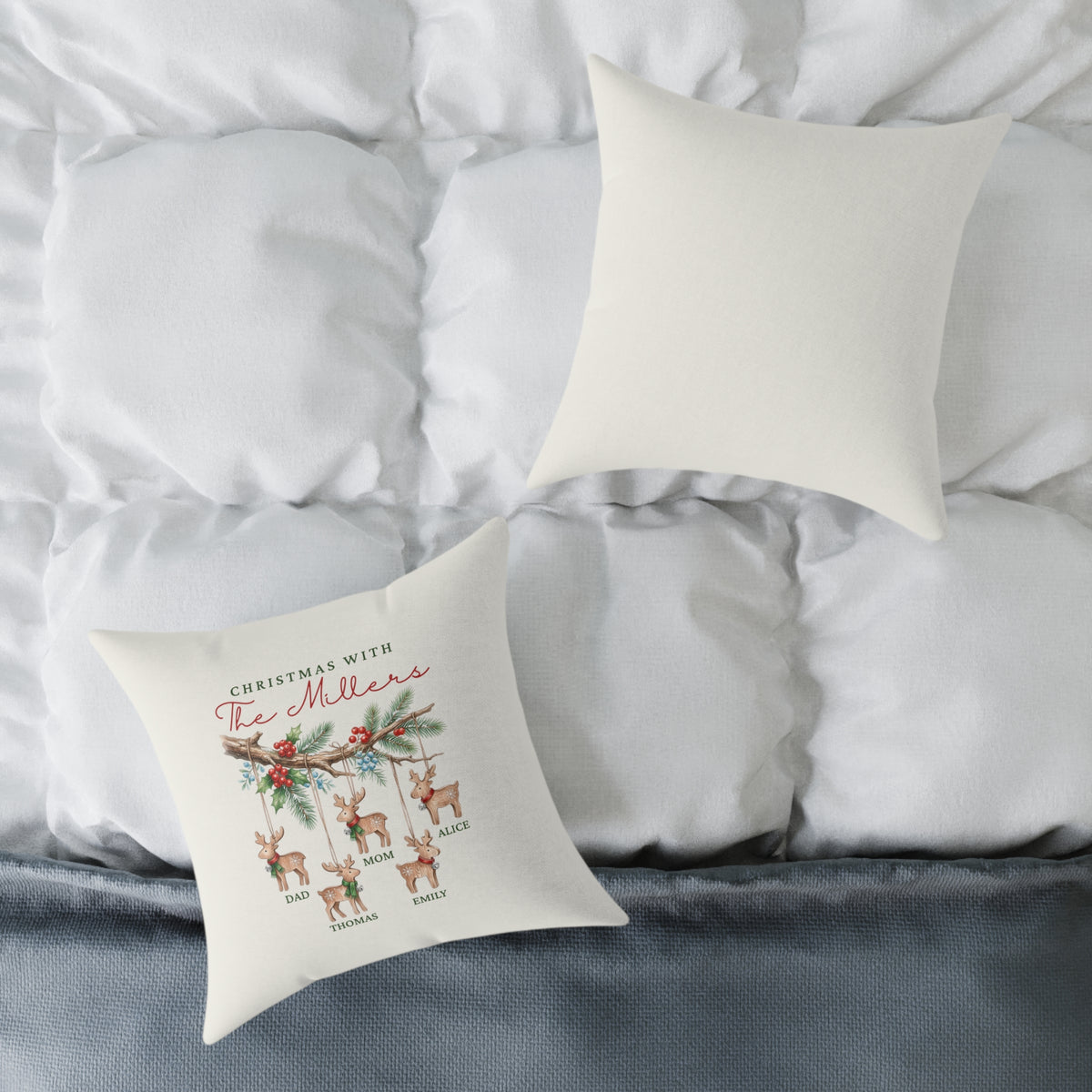 Front and back of the personalized reindeer ornaments family names Christmas pillow on a white bed