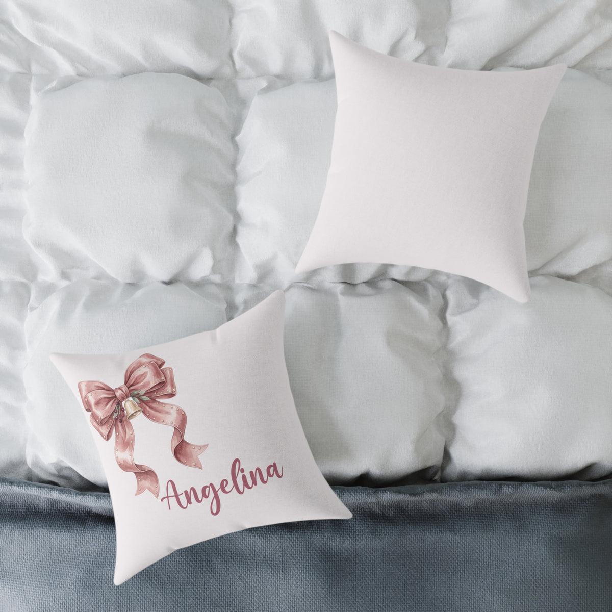 Front and back of the personalized pink ribbon bow name pillow on a white bed