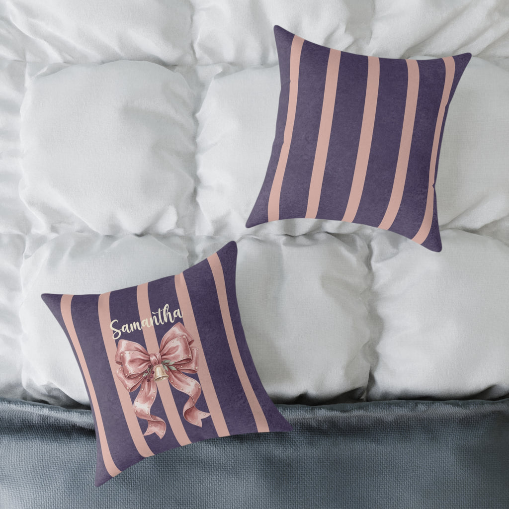 Front and striped back of the personalized pink bow name pillow on a white bed