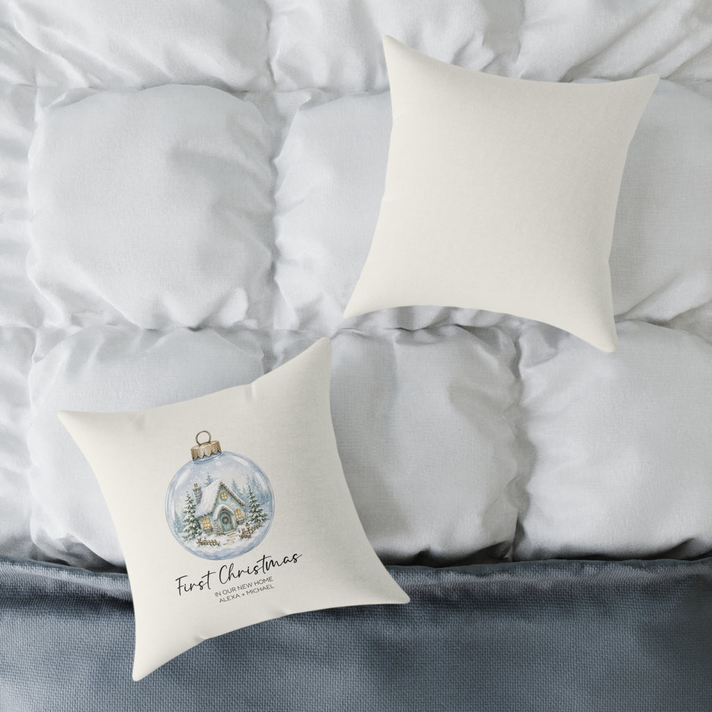 Front and back of the personalized first Christmas in our new home snow globe pillow on a white bed