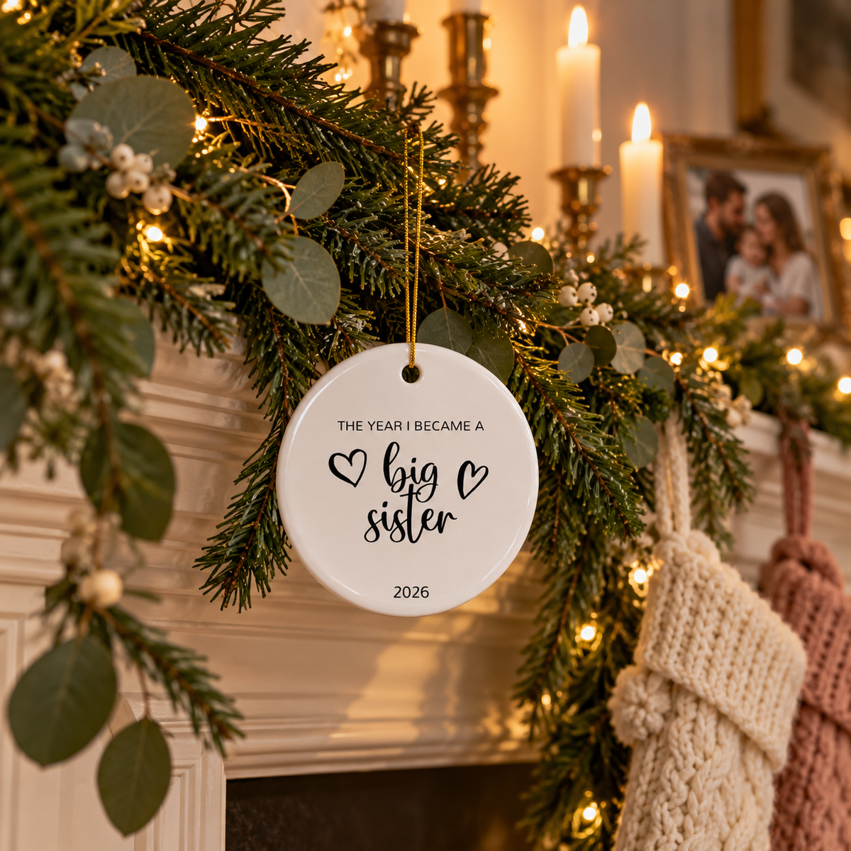 Personalized The Year I Became a Big Sister Christmas ornament on a fireplace garland with stockings