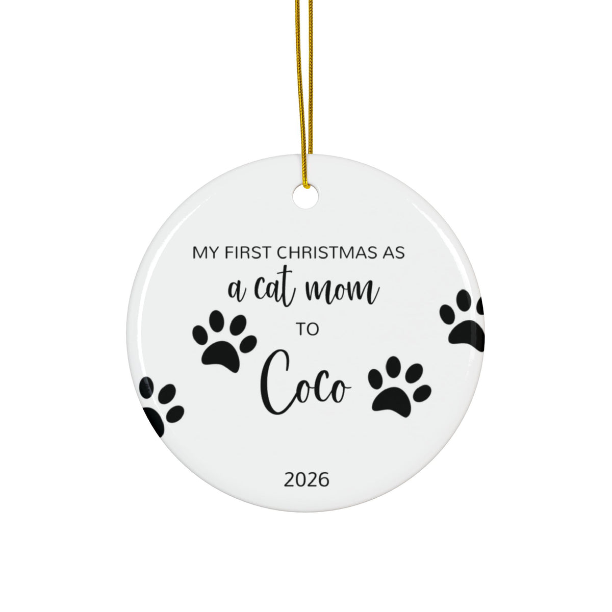 Personalized cat mom first Christmas ornament with paw prints and black script name, front side