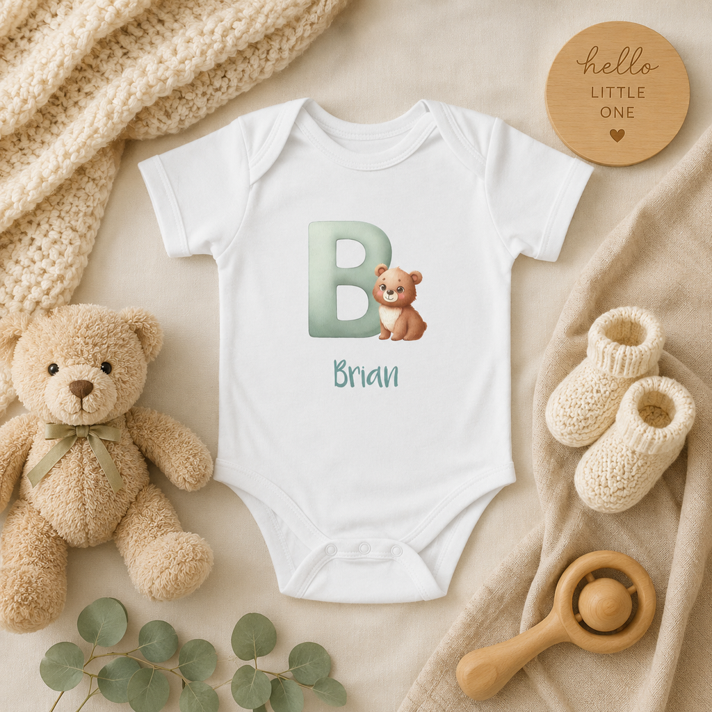 Initial B baby bodysuit with bear and name in script – front view flat lay
