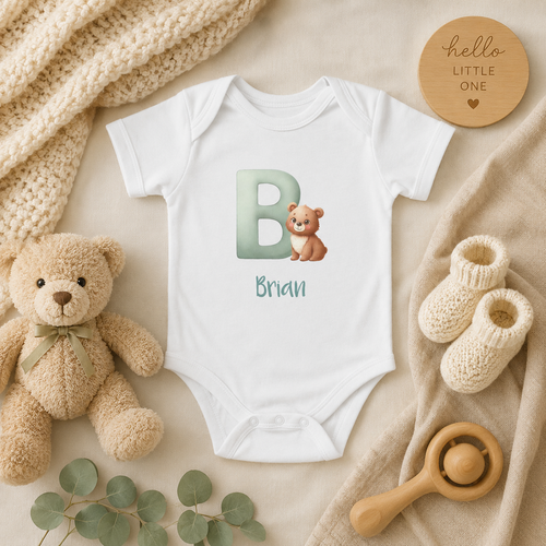 Initial B baby bodysuit with bear and name in script – front view flat lay