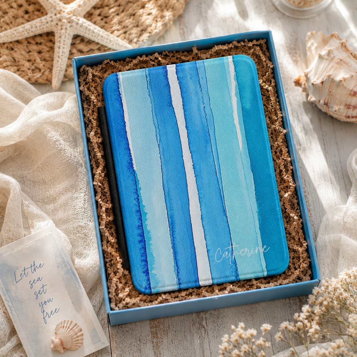 Personalized blue watercolor stripes Kindle case shown in a gift setting