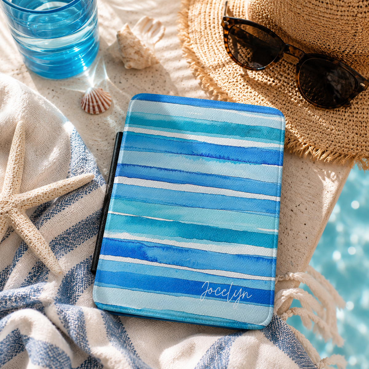 Personalized blue watercolor stripes horizontal Kindle case styled in a lifestyle reading setting