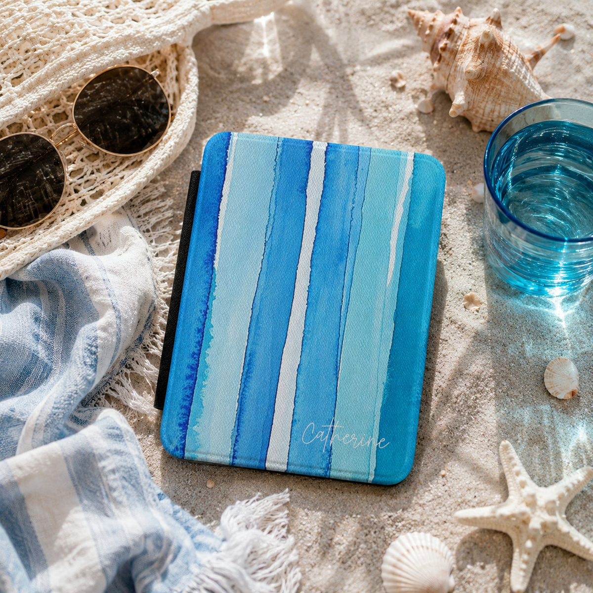 Personalized blue watercolor stripes Kindle case styled in a lifestyle reading setting