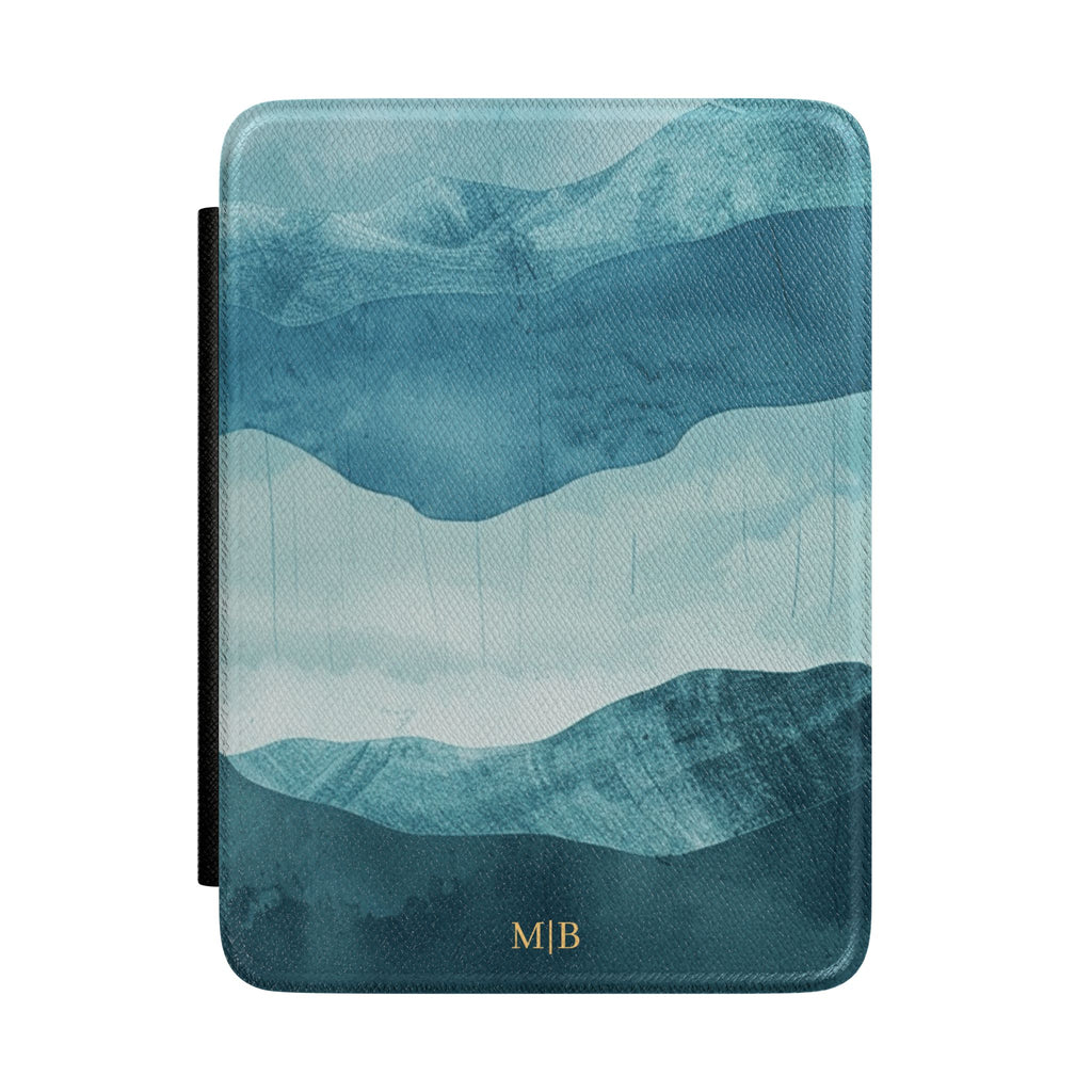 Layered blue watercolor mountain personalized Kindle case with gold initials, front view