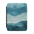 Layered blue watercolor mountain personalized Kindle case with gold initials, front view