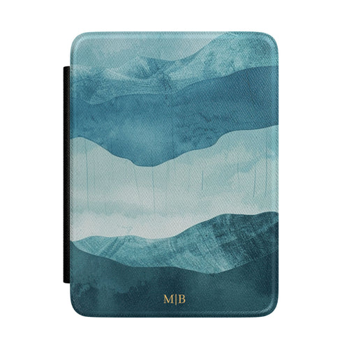 Layered blue watercolor mountain personalized Kindle case with gold initials, front view
