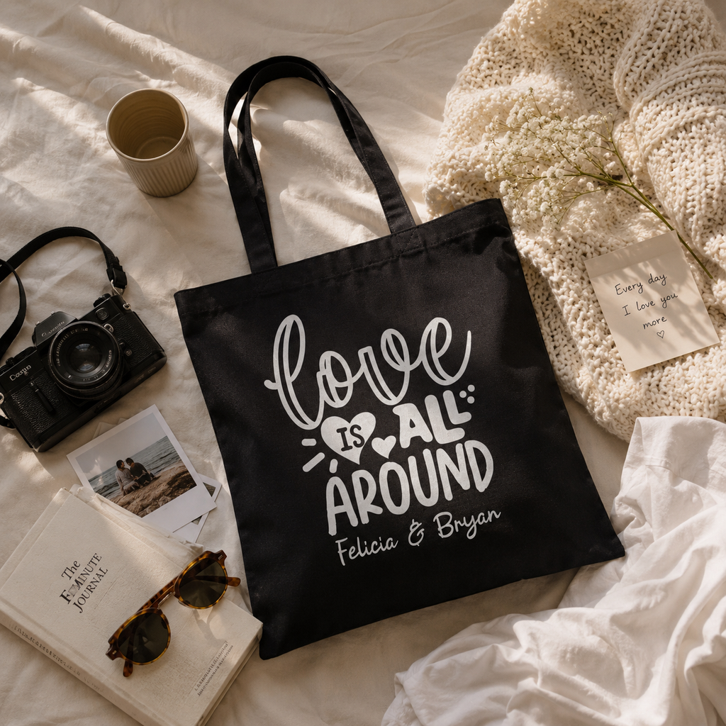Close-up of love is all around print and custom names on canvas tote bag