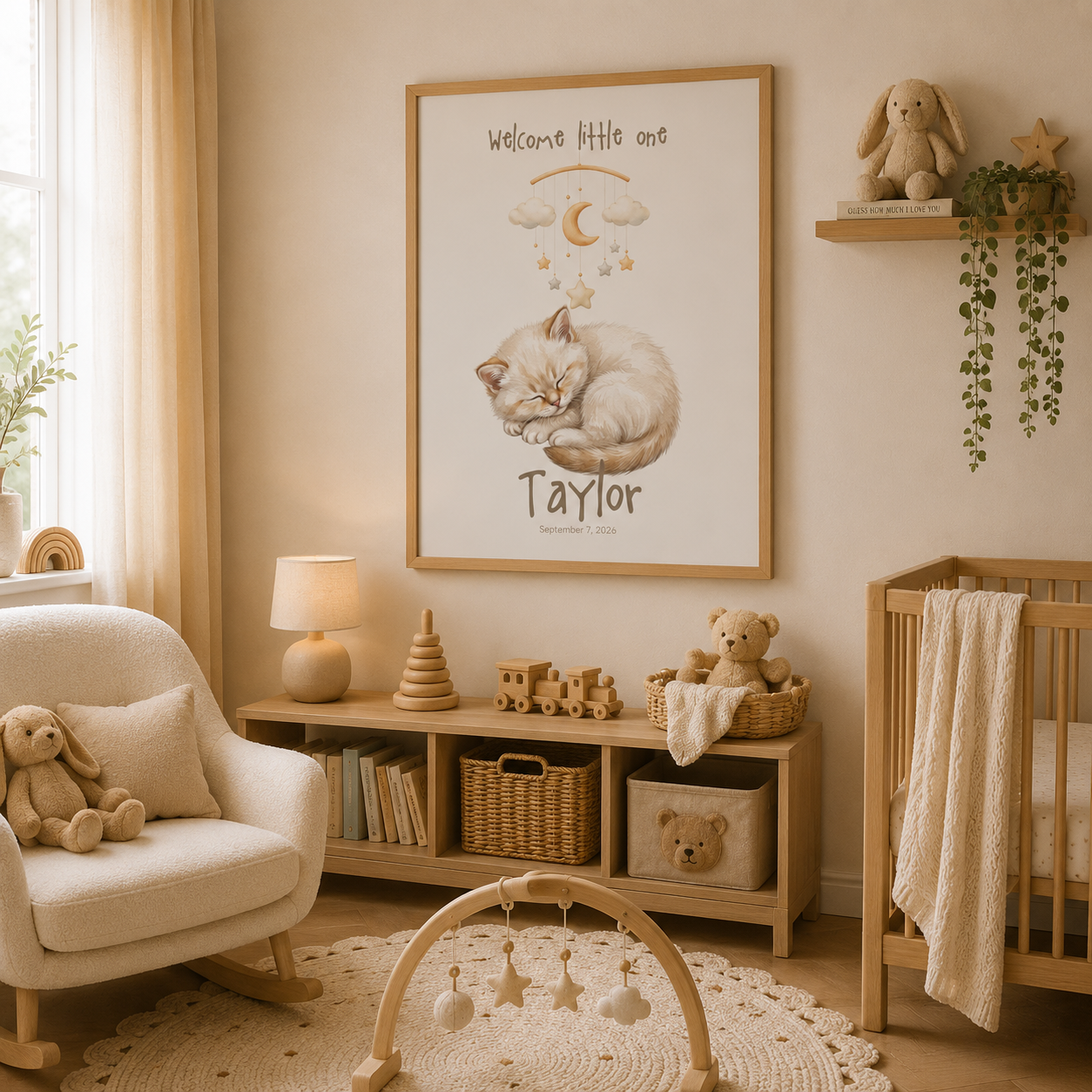 Cream kitten curled up under mobile baby name poster in nursery room